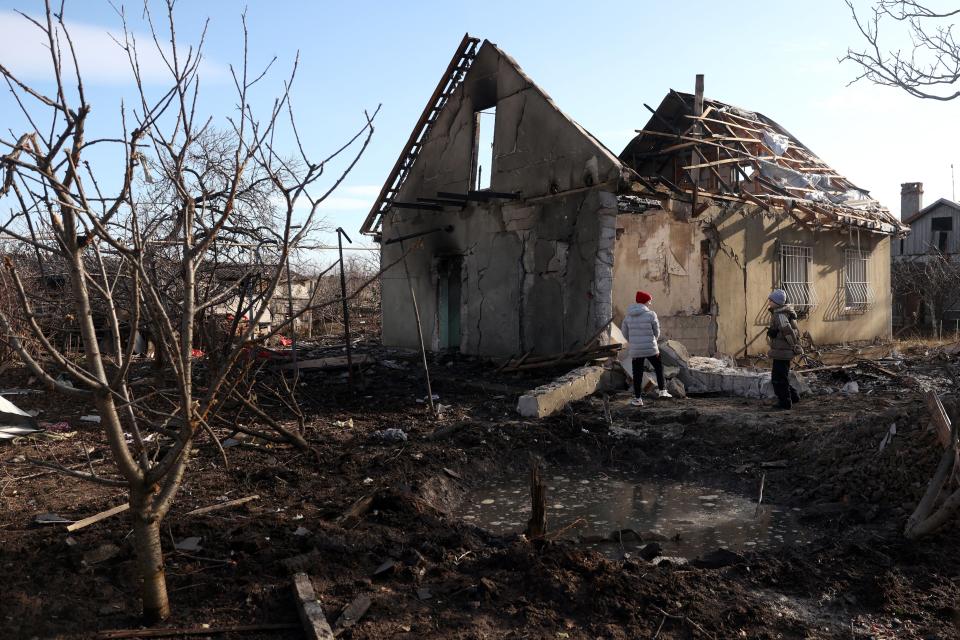 Children stand next to a crate in front of a house destroyed in a drone attack (AFP via Getty Images)