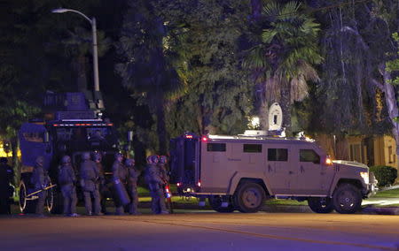 Police officers and their vehicles line the street outside the house of one of the suspects in a mass shooting in Redlands, California December 2, 2015. REUTERS/Mario Anzuoni