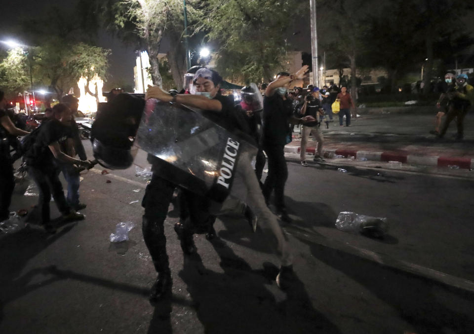 A man clashes with riot police during dispersal of protesters who removed container vans used as a barricade in front of the Grand Palace Saturday, March 20, 2021 in Bangkok, Thailand. Thailand's student-led pro-democracy movement is holding a rally in the Thai capital, seeking to press demands that include freedom for their leaders, who are being held without bail on charges of defaming the monarchy. (AP Photo/Sakchai Lalit)