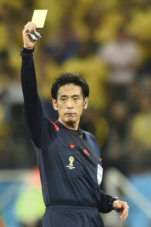 Japanese referee Yuichi Nishimura shows the yellow card during the World Cup opening match between Brazil and Croatia at the Corinthians Arena in Sao Paulo on June 12, 2014