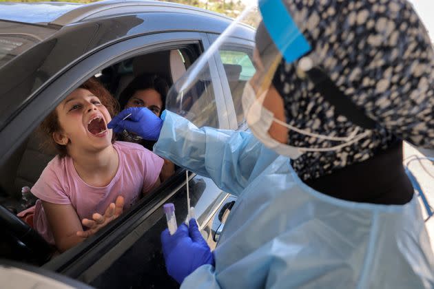 A medic performs a COVID-19 coronavirus swab test on a child in a vehicle at a Home Front command drive-through coronavirus testing complex in Jerusalem on July 29, 2021. (Photo by MENAHEM KAHANA / AFP) (Photo by MENAHEM KAHANA/AFP via Getty Images) (Photo: MENAHEM KAHANA via Getty Images)