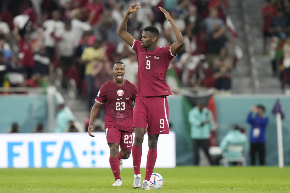Qatar's Mohammed Muntari, front, celebrates after scoring his side's opening goal during the World Cup group A soccer match between Qatar and Senegal, at the Al Thumama Stadium in Doha, Qatar, Friday, Nov. 25, 2022. (AP Photo/Darko Bandic)