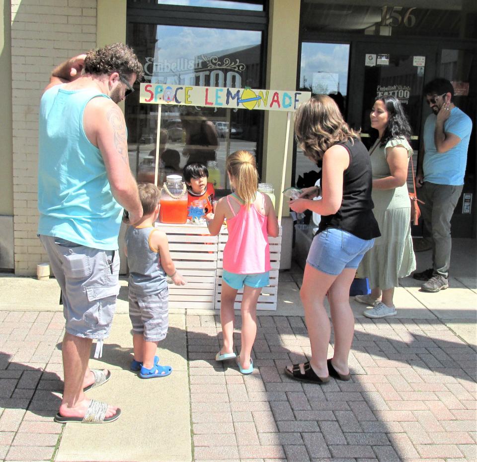 Five-year-old Marcos Patino takes care of customers with help from his parents at Space Lemonade Stand on East Liberty Street in downtown Wooster.