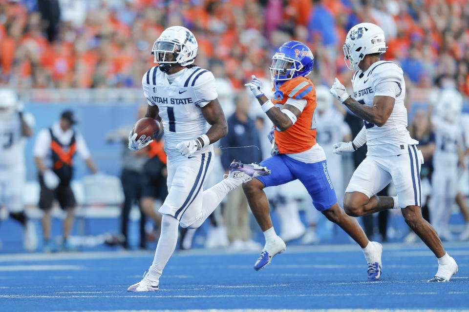 Utah State wide receiver Jalen Royals (1) runs past the Boise State defense on a 75-yard touchdown reception in the first half of an NCAA college football game, Saturday, Oct. 5, 2024, in Boise, Idaho. . (AP Photo/Steve Conner)