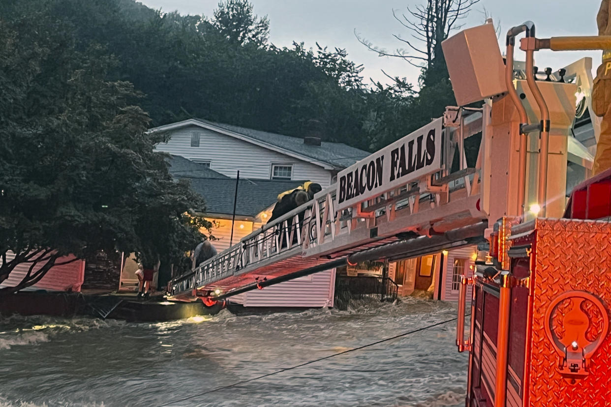 This photo provided by Beacon Hose Co. No. 1, a fire station in Beacon Falls, Connecticut, shows members of Beacon Hose Co. rescuing people from the Brookside Inn in Oxford, Conn., Sunday, Aug. 18, 2024. (Beacon Hose Co via AP)