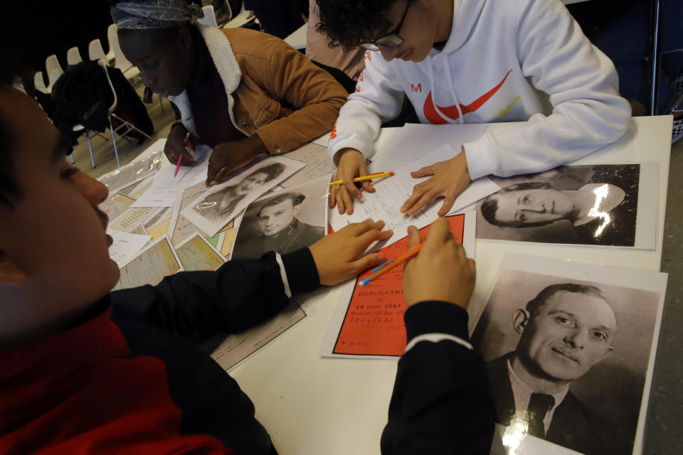 In this photo taken on Thursday Jan. 30, 2020, students work on deportees files during a workshop dedicated to the Holocaust remembrance at the Drancy Shoah memorial, outside Paris. A French Holocaust survivor Victor Perahia was 9 when his family was seized by the Nazis, and couldn't bear to speak about what happened for 40-years, but is now telling his story to schoolchildren at Drancy, backdropped by the buildings that once imprisoned him. (AP Photo/Christophe Ena)