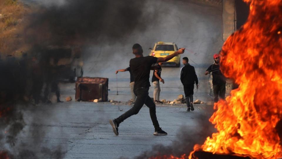 A Palestinian demonstrator throws rocks towards Israeli soldiers during clashes in the city of Ramallah in the occupied West Bank. Picture: Jaafar Ashtiyeh/AFP