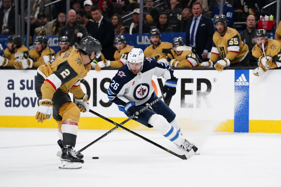 Winnipeg Jets right wing Blake Wheeler (26) skates with the puck against Vegas Golden Knights defenseman Zach Whitecloud (2) during the third period of Game 2 of an NHL hockey Stanley Cup first-round playoff series Thursday, April 20, 2023, in Las Vegas. (AP Photo/Lucas Peltier)