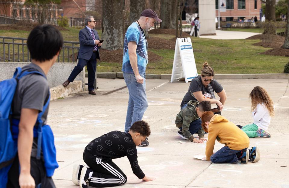 Planetarium worker John Graziano watches over youngsters as they color on the sidewalk at the mall. Hundreds come out to Ocean County College to watch the Solar Eclipse on the mall in front of the Robert J. Novins Planetarium.