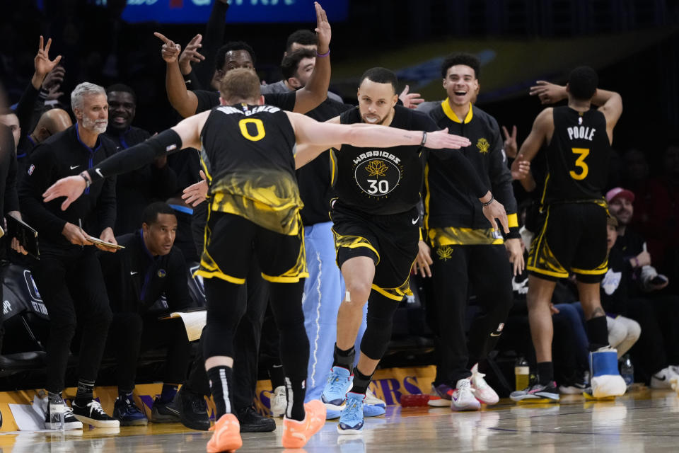 Golden State Warriors' Stephen Curry (30) celebrates after his 3-point basket with Donte DiVincenzo (0) during the first half of an NBA basketball game against the Los Angeles Lakers, Sunday, March 5, 2023, in Los Angeles. (AP Photo/Jae C. Hong)