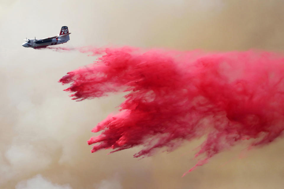 A CAL FIRE aircraft drops Phos-Chek on the Oak Fire near Darrah in Mariposa County, Calif., on July 24, 2022.<span class="copyright">David Swanson—Reuters</span>