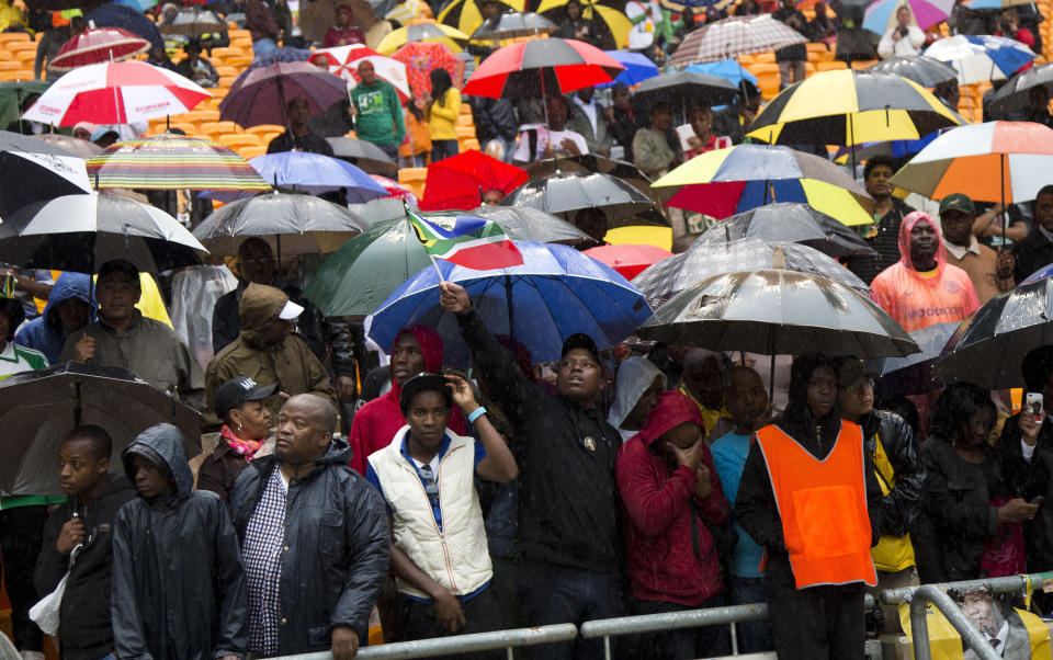 People watch as President Barack Obama speaks to crowds attending the memorial service for former South African president Nelson Mandela at the FNB Stadium in Soweto near Johannesburg, Tuesday, Dec. 10, 2013. (AP Photo/Evan Vucci)