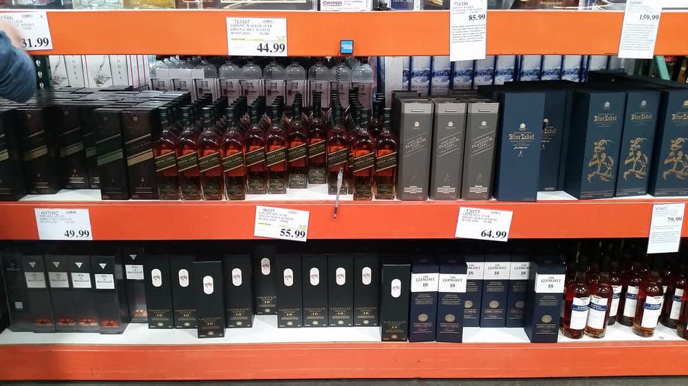 Bottles of various alcohol on the shelves of a Costco warehouse.