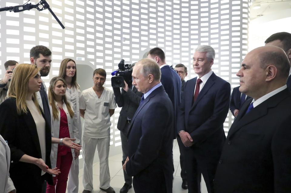 In this photo taken on Tuesday, March 17, 2020, Russian President Vladimir Putin, center, Prime Minister Mikhail Mishustin, right, and Moscow Mayor Sergei Sobyanin, second right, listen to employees of a call center of the emergency response center on control and monitoring of the coronavirus disease, in Moscow, Russia. Russian authorities declared a war on "fake news" related to the new coronavirus. The crusade was triggered by what looked like a real disinformation campaign, but as the outbreak in Russia picked up speed and criticism of the Kremlin's "it is under control" stance mounted, the authorities cracked down on social media users doubting the official numbers and news outlets questioning the government's response to the epidemic. (Mikhail Klimentyev, Sputnik, Kremlin Pool Photo via AP)