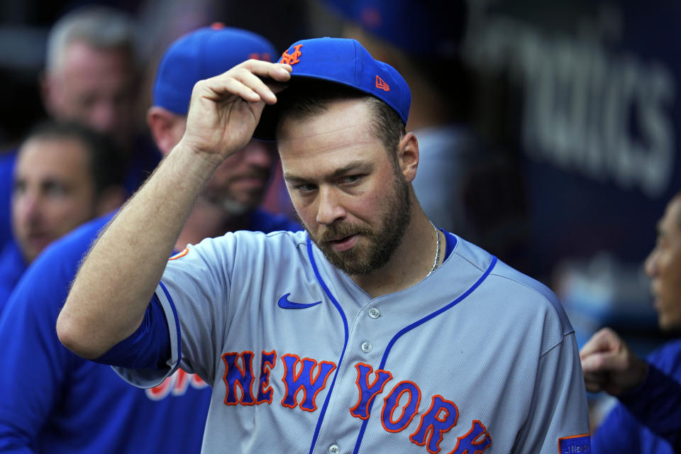 New York Mets starting pitcher Tylor Megill takes off his cap in the dugout before a baseball game against the Pittsburgh Pirates in Pittsburgh, Friday, June 9, 2023. (AP Photo/Gene J. Puskar)