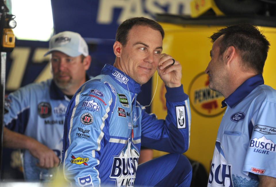 Driver Kevin Harvick, center, talks with his crew chief Rodney Childers as he waits for the beginning of a practice session for this weekend’s NASCAR Cup Series auto race at Kansas Speedway Friday, May 11, 2018, in Kansas City, Kan. (AP Photo/Ed Zurga)