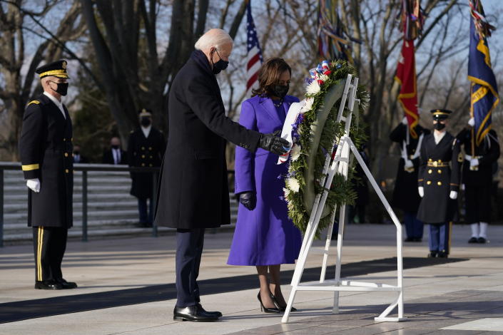 FILE - In this Wednesday, Jan. 20, 2021 file photo, President Joe Biden and Vice President Kamala Harris participate in a wreath laying ceremony at the Tomb of the Unknown Soldier at Arlington National Cemetery in Arlington, Va. On Friday, Feb. 19, 2021, The Associated Press reported on a video circulating online incorrectly asserting that footage shows certain aspects of the wreath-laying ceremony for President Joe Biden at the Tomb of the Unknown Soldier on Jan. 20 were different from past presidents’ ceremonies, proving Biden’s inauguration was fake. Differences between Biden’s ceremony at the Arlington National Cemetery and other presidential wreath-laying ceremonies in the past can be attributed to cold weather and coronavirus precautions, according to a spokesperson for the U.S. Army Military District of Washington. (AP Photo/Evan Vucci)