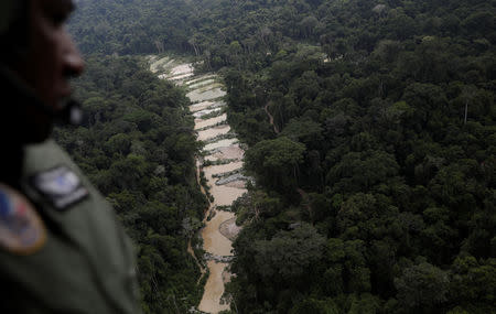 A policeman observes an illegal gold mine during an operation conducted by agents of the Brazilian Institute for the Environment and Renewable Natural Resources, or Ibama, in national parks near Novo Progresso, southeast of Para state, Brazil, November 4, 2018. REUTERS/Ricardo Moraes