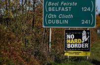 FILE PHOTO: A 'No hard Border' poster is seen below a road sign on the Irish side of the border between Ireland and Northern Ireland near Bridgend