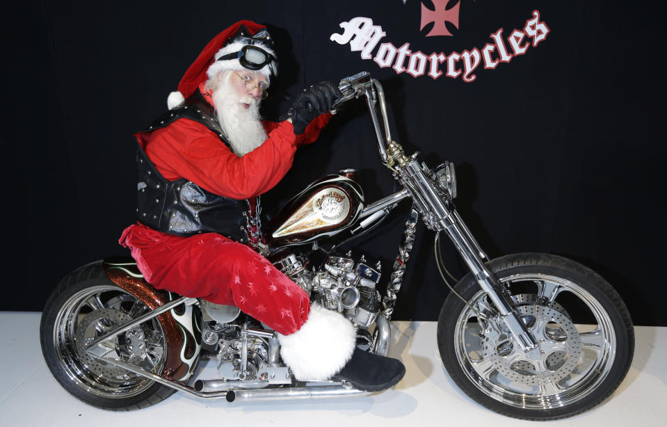 Actor Brady White portrays Santa Claus as he sits atop the Indian Larry's "Wild Child" Motorcycle during the unveiling of the gifts included in the Neiman Marcus Christmas Book Tuesday, Oct. 8, 2013, in Dallas. Hand built in Brooklyn, the bike is on sale for $750,000. (AP Photo/LM Otero)