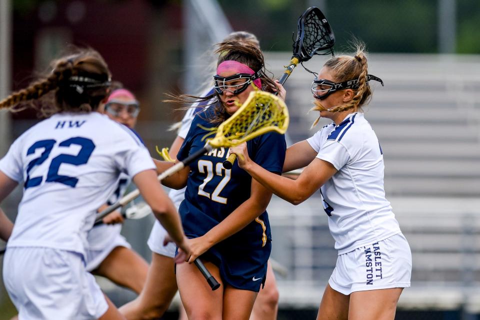 Haslett-Williamston's Breyer Fenech, right, and Abby Russell, left, pressure East Grand Rapids' Elizabeth Grin during the second half on Wednesday, June 7, 2023, at East Lansing High School.