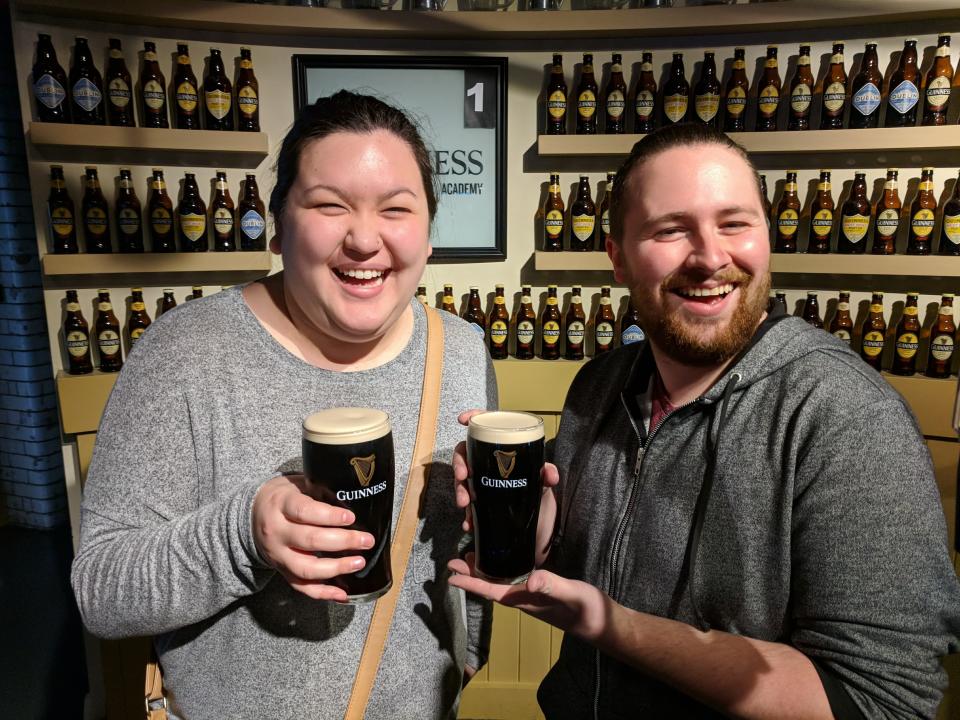 The author and her husband holding Guiness beers in Ireland