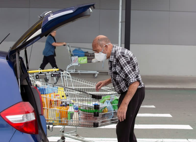 Brian Green, 76, wears a mask as he wheels his supermarket shopping cart to his car outside Pak'nSave supermarket amid the spread of the coronavirus disease (COVID-19) in Christchurch