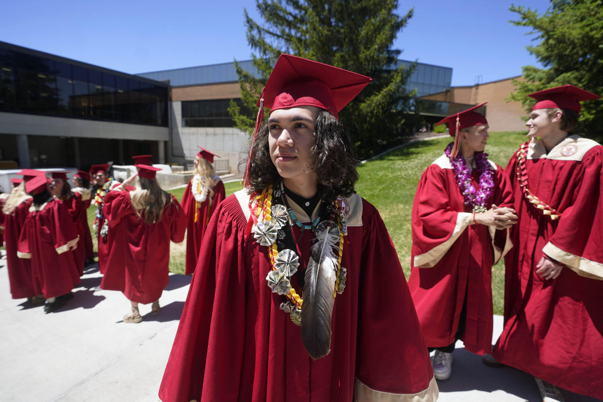 Elijah Wiggins wears an eagle feather at his graduation from Cedar City High School Wednesday from Cedar City High School on Wednesday, May 25, 2022, in Cedar City, Utah. Wiggins crossed the stage to accept his diploma wearing an eagle feather that his uncle, Hoksila Lakota, had gifted him ahead of the ceremony to celebrate his graduation. (AP Photo/Rick Bowmer)