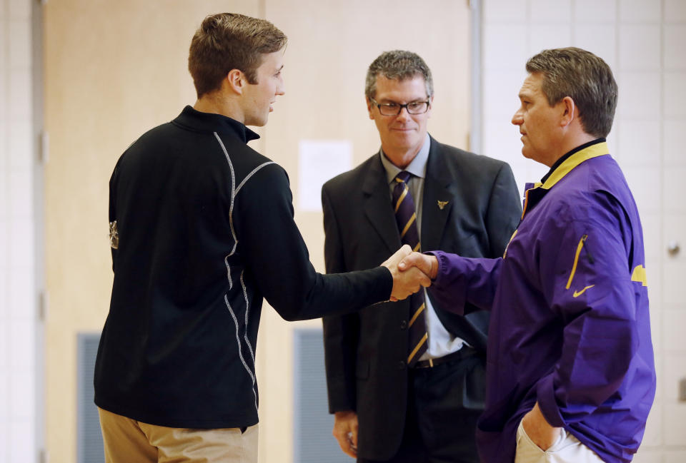 Minnesota State, Mankato defensive back Sam Thompson left, shakes hands with coach Todd Hoffner, as athletic director Kevin Buisman watches on Thursday April 17, 2014, in Mankato , Minn. Players ended their boycott of spring practice and said Thursday they will play for Hoffner, who was reinstated after being exonerated of having child pornography on his cellphone. (AP Photo/Star Tribune, Jerry Holt) ST. PAUL OUT MINNEAPOLIS-AREA TV OUT MAGS OUT
