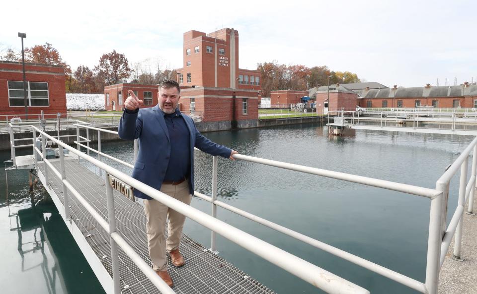 Jeffrey Bronowski, Akron water supply bureau manager, stands on a walkway with a building constructed in 1915 behind him and a settling basin below him at the Akron Water Supply Plant near Lake Rockwell in Kent.