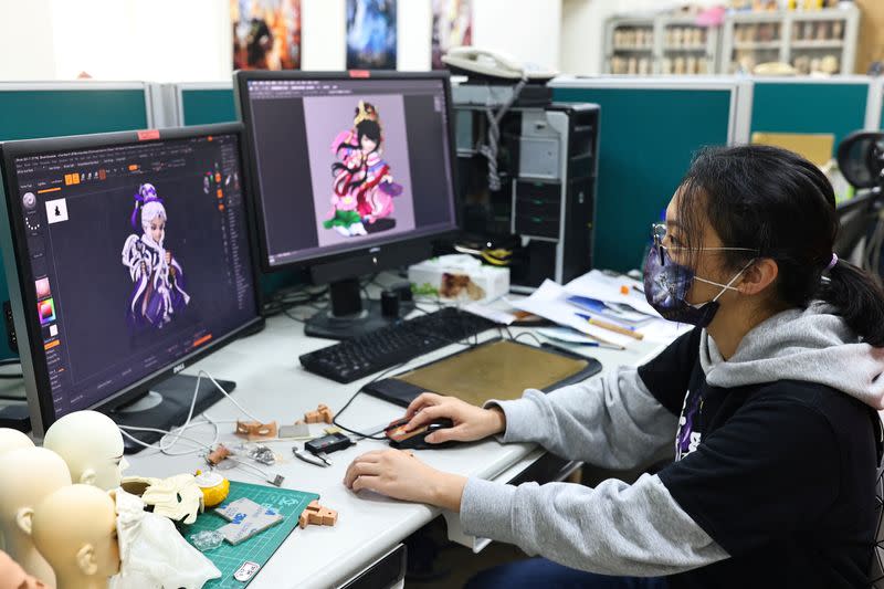 Seika Huang, brand director of Pili International Multimedia, looks at designs of characters that are turned into NFT files at their headquarters in Yunlin, Taiwan