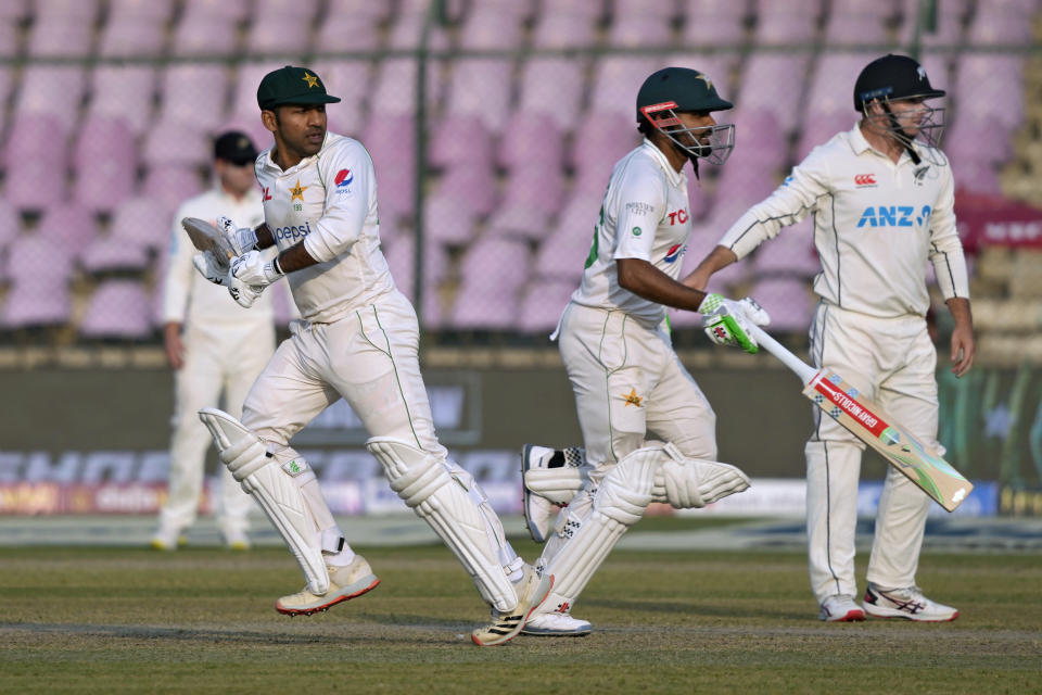 Pakistan's Sarfaraz Ahmed, left, and Babar Azam, second right, run between the wickets during the first day of first test cricket match between Pakistan and New Zealand, in Karachi, Pakistan, Monday, Dec. 26, 2022. (AP Photo/Fareed Khan)