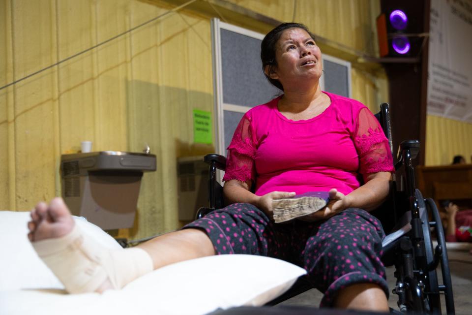 Reyna Gloria Dominguez, 42, from Honduras, grips a bible and tears up recounting her journey, at Mission: Border Hope on Friday in Maverick County, Texas. Dominguez said she injured her foot in Monterrey fleeing from gunman.