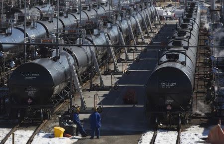 Irving Oil workers inspect rail cars carrying crude oil at the Irving Oil rail yard terminal in Saint John, New Brunswick in this March 9, 2014 file photo. REUTERS/Devaan Ingraham/Files