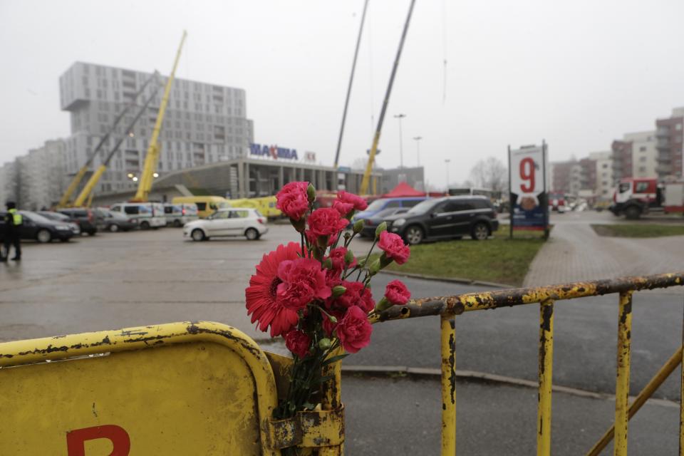 Flowers are placed near a collapsed supermarket in capital Riga