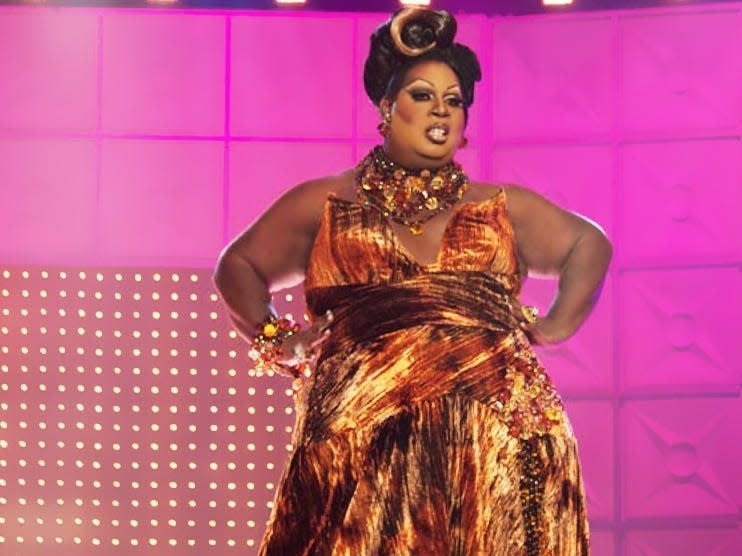 Latrice Royale in a gold gown with hair up on stage at drag race