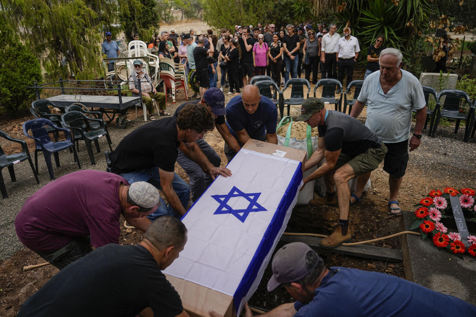 Covered with the Israeli flag, the body of Roi Popplewell is buried at kibbutz Yagur near Haifa, north Israel, Friday, Oct. 27, 2023. (AP Photo/Ariel Schalit)