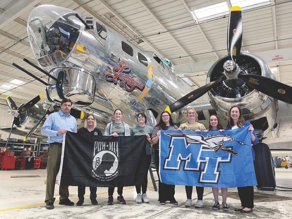 In this 2022 file photo, a group of MTSU faculty and students proudly display a POW-MIA and MT flag during their visit to view a B-17 aircraft at the Commemorative Air Force Museum in Arizona. The visit was part of the research by the study abroad group in its efforts to help repatriate the remains of tens of thousands of American service personnel who are unaccounted for from past conflicts, many from World War II.