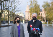 Lithuania's President Gitanas Nauseda, right, with his wife Diana Nausediene, wearing face masks to protect against coronavirus, speaks to the media at a polling station during the early voting in the second round of a parliamentary election in Vilnius, Lithuania, Thursday, Oct. 22, 2020. Lithuanians will vote in the second round of a parliamentary election on upcoming Sunday during the rise in the incidence of coronavirus infection in the country. (Lithuanian President Office via AP)