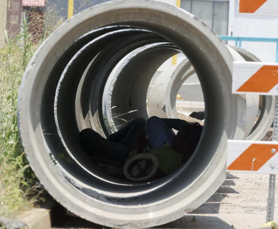 A construction worker takes a break from the sun while sitting in the shade of a concrete pipe near downtown Waco, Texas, Friday, June 16, 2023. Temperatures are expected to reach the 100 degree Fahrenheit mark for the next several days. (Rod Aydelotte/Waco Tribune-Herald via AP)