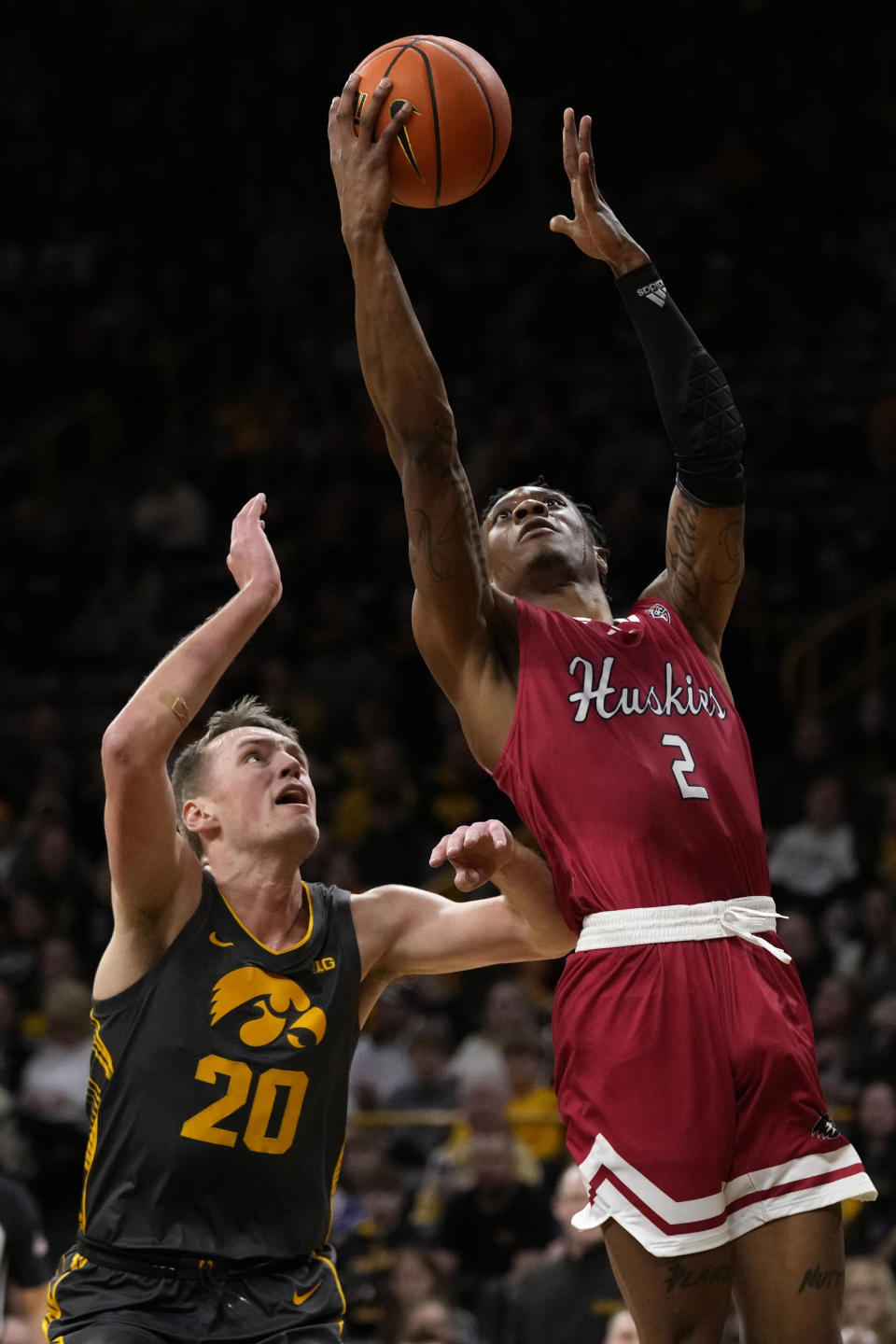 Northern Illinois guard Zarique Nutter (2) drives to the basket over Iowa forward Payton Sandfort (20) during the first half of an NCAA college basketball game, Friday, Dec. 29, 2023, in Iowa City, Iowa. (AP Photo/Charlie Neibergall)