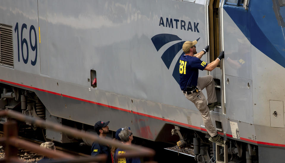 A Federal Bureau of Investigation agent boards an Amtrak train after a shooting aboard the train in downtown Tucson, Ariz., on Monday, Oct. 4, 2021. (Rebecca Sasnett/Arizona Daily Star via AP)