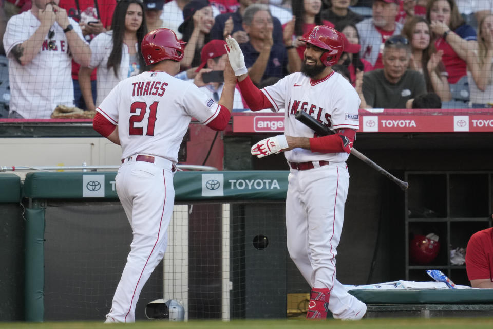 Los Angeles Angels' Matt Thaiss (21) high-fives Anthony Rendon after scoring off of a single by Mike Trout third inning of a baseball game against the Kansas City Royals in Anaheim, Calif., Saturday, April 22, 2023. (AP Photo/Ashley Landis)