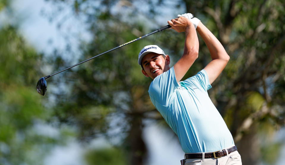   Mac Meissner strikes his tee shot in a blue shirt 