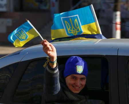 A man waves national Ukraine flags from a car in the town of Slavyansk, October 25, 2014. REUTERS/Vasily Fedosenko