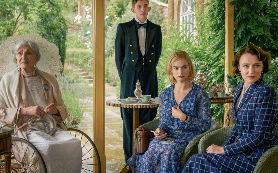 A scene from Rebecca (2020) starring Jane Lapotaire as Granny, Ashleigh Reynolds as Robert, and Lily James as Daphne and Keeley - Kerry Brown / Netflix 