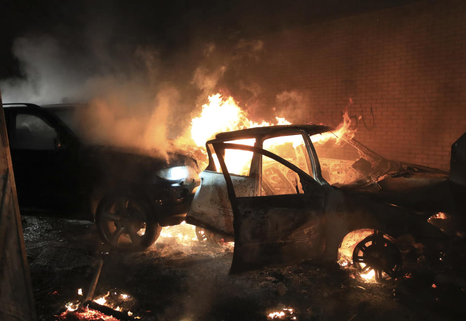 Hijacked cars burn at the peace wall on Lanark Way as rioting broke out in West Belfast, Northern Ireland, Wednesday, April 7, 2021. The police had to close roads into the nearby Protestant area as crowds from each divide attacked each other. (AP Photo/Peter Morrison)