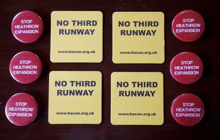 Badges and beer mats, protesting at the proposed expansion of Heathrow airport, are seen inside a pub in the village of Harmondsworth, adjacent to the airport in London, Britain July 1, 2015. REUTERS/Peter Nicholls