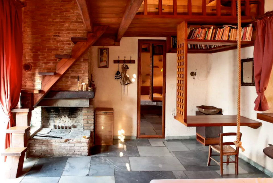 <p>Here’s a look at one of the bedroom’s fireplaces and stairs to its loft. (Airbnb) </p>