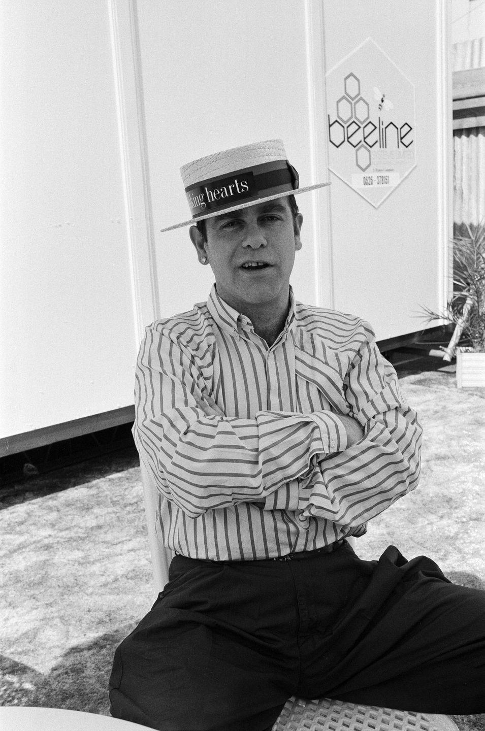 <p>While on his 1984 Breaking Hearts Tour, Elton John took part in the Summer of 84 concert at Wembley Stadium. Here, he wears a relatively casual ensemble, complete with a Breaking Hearts hat, prior to his performance. </p>